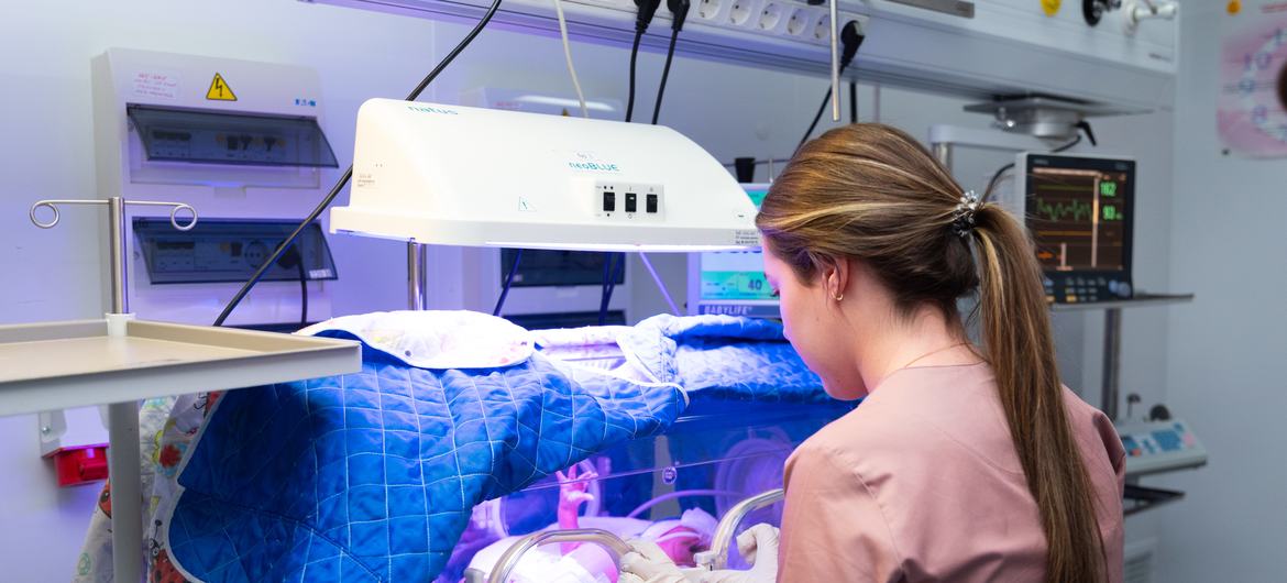 Uma profissional de saúde cuida de um recém-nascido em uma incubadora na Ucrânia