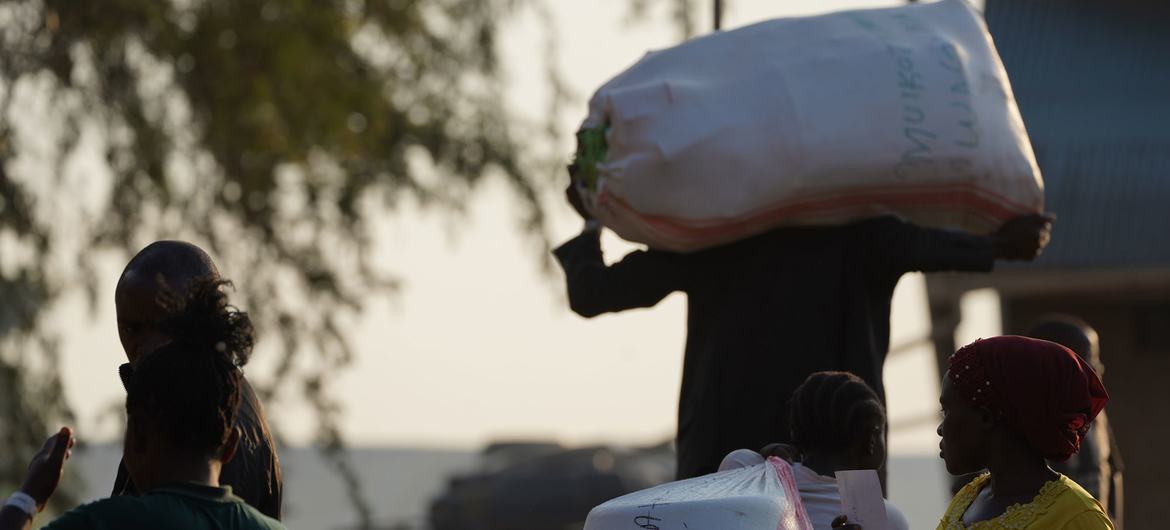 Um refugiado carrega pertences após cruzar para Uganda a partir da República Democrática do Congo