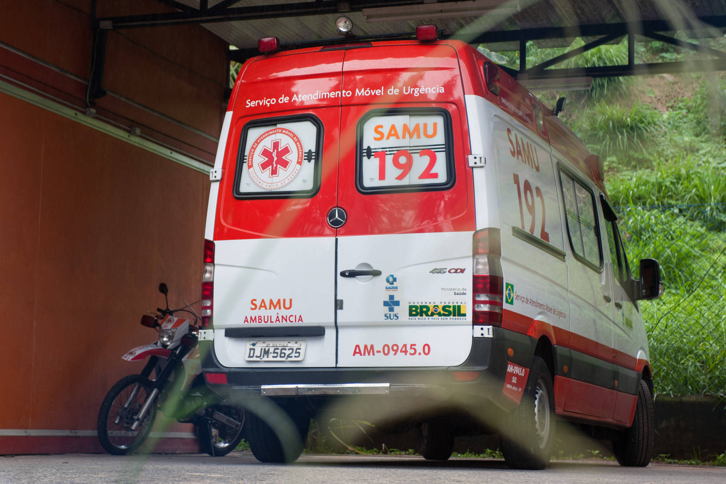Ambulância estacionada ao lado de moto em uma garagem