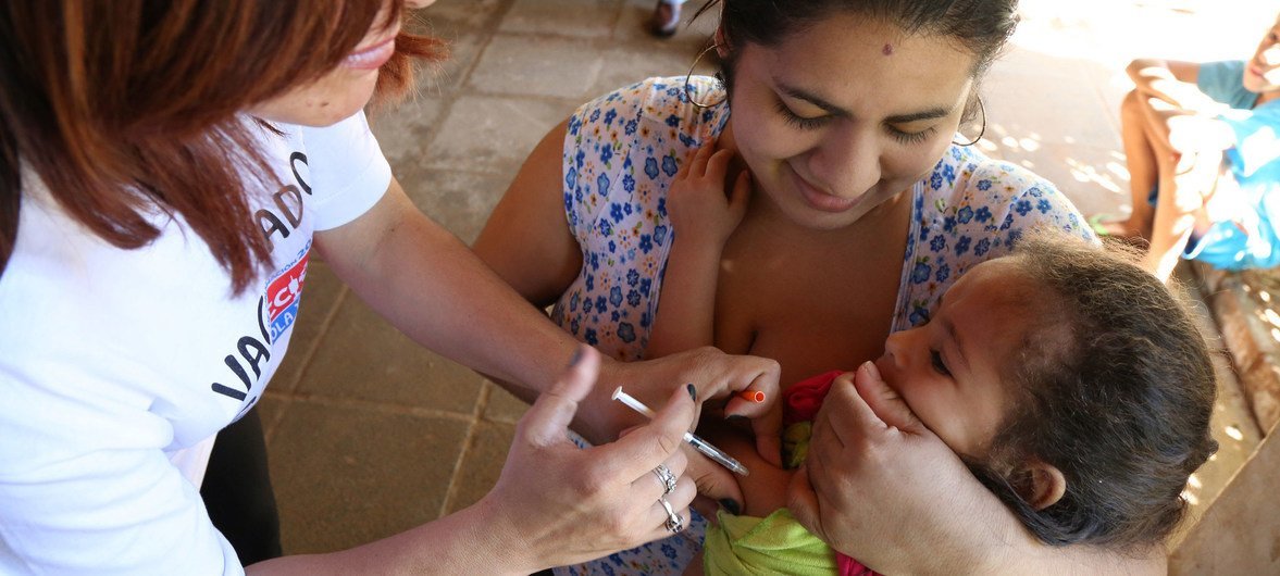 Enfermeira vacina uma criança contra o sarampo no Paraguai