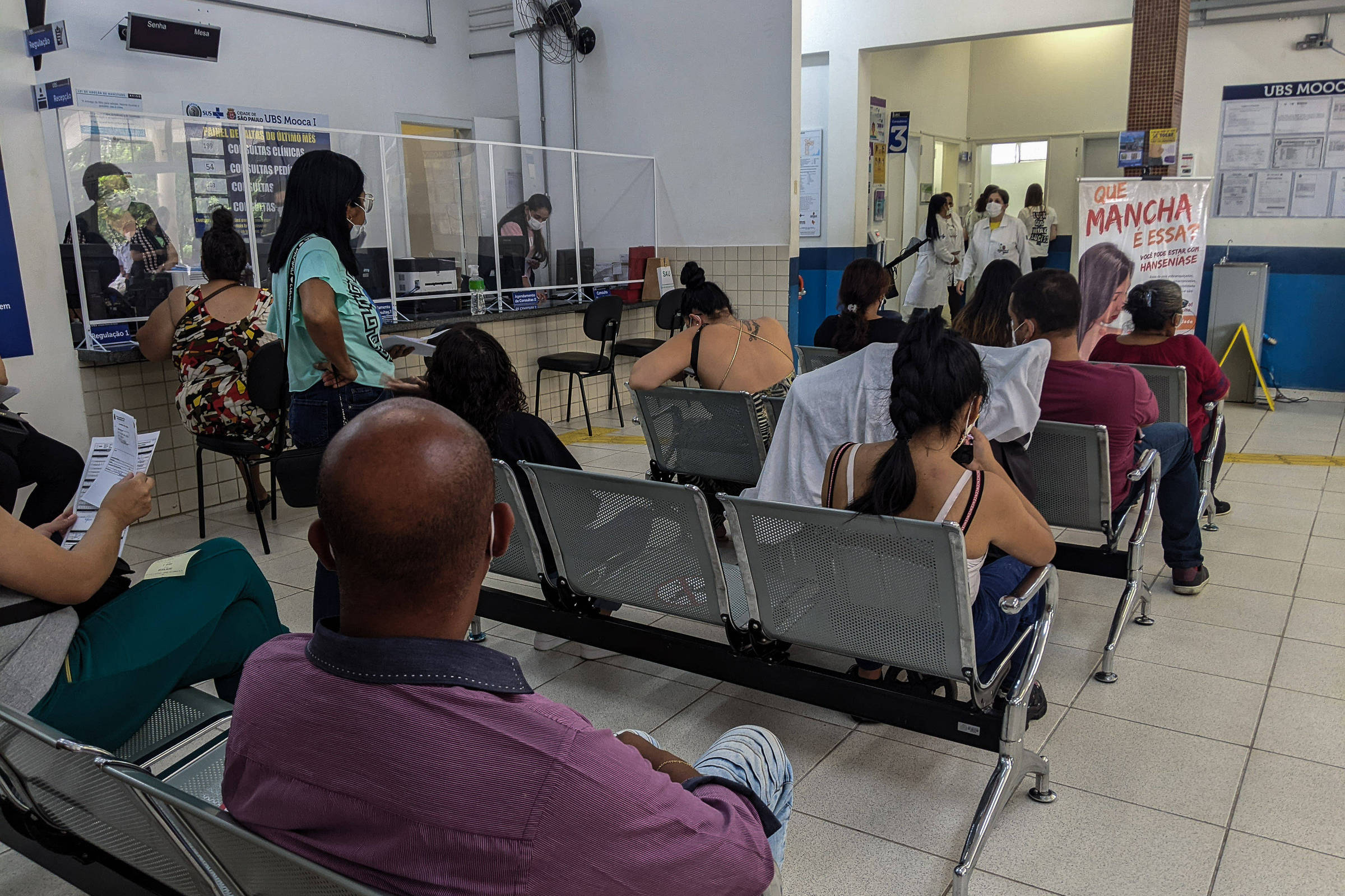 Pessoas aguardam atendimento sentadas em bancos da UBS